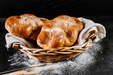 Siyah ahşap arka planda sepetin içinde taze çörekler