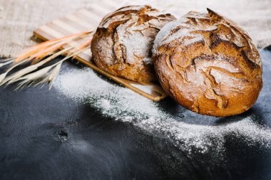 Siyah ahşap arka planda malzemeleri olan tatlı taze ekmek.