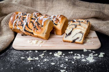 Ahşap zemin üzerinde haşhaş tohumu olan lezzetli çörek.