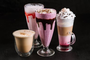 Siyah arka planda farklı kahve bardakları.