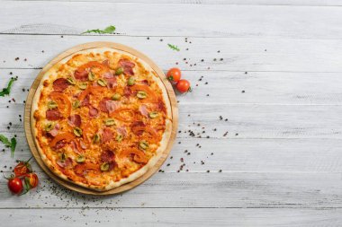 Beyaz ahşap arka planda mozarella, salam ve zeytinli lezzetli pizza Chachatore.