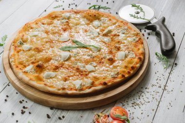 Mozzarella, emental peynirli pizza ve ahşap arka planda Philadelphia peyniri.