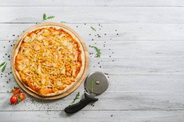Mozzarella soslu pizza, tavuk fileto, ananas ve mısır.