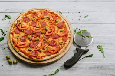 Domates soslu nefis pizza, mozzarella ve ahşap arka planda jambon.