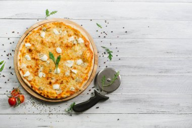 Mozzarella, emental peynirli pizza ve ahşap arka planda Philadelphia peyniri.