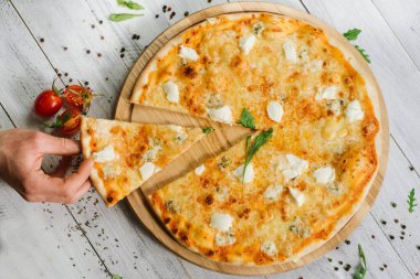 Mozzarella, emental peynirli pizza ve ahşap arka planda Philadelphia peyniri.