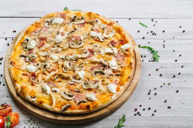 Mozarella, mırıldanma, tavuk filetosu ve beyaz ahşap arka planda şampanyalar olan lezzetli bir pizza.