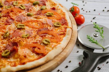 Beyaz ahşap arka planda mozarella, salam ve zeytinli lezzetli pizza Chachatore.