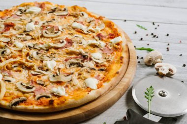 Mozarella, mırıldanma, tavuk filetosu ve beyaz ahşap arka planda şampanyalar olan lezzetli bir pizza.
