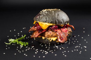 Köfteli, pastırmalı, peynirli ve vişneli lezzetli siyah hamburger.