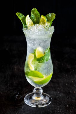 Siyah zemin üzerinde buz ve limonlu taze mojito.