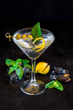 Siyah arka planda zeytinli şeffaf kokteyl.