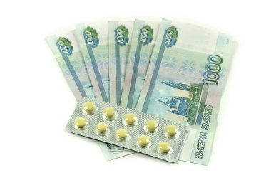 Banknotlarda binlerce ruble ve sarı haplar var. Rus parası ve tıbbi malzemeler. Tedavi için ilaç almak pahalıdır..
