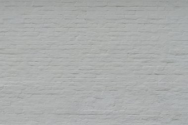 Eski beyaz boyalı tuğla duvar. Kırık tuğla desenli beyaz zemin ve büyük bir boya tabakası..