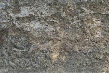 Doğal gri yıpranmış taş dokusu. Duvarı ya da yüzey yüzeyini çizgilerle kaplayan taşın arka planı. Erozyonu olan eski bir taş..