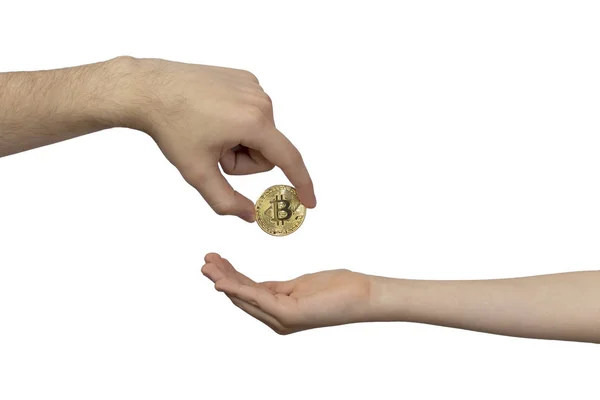 Kripto para miras konsepti. Bir yetişkinin eli, altın Bitcoin 'i çocukların eline aktarır..