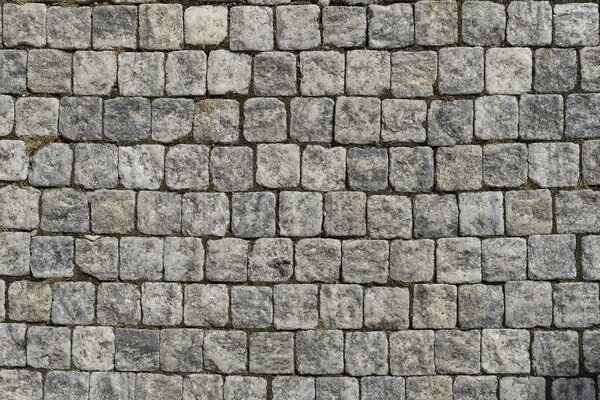 European cobblestone pavement square. Gray stone background, textured pedestrian pavement, road in Europe.