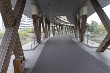 Nehrin karşısındaki yol köprüsü asfaltla kaplı. Ekolojik tahta direkler ve yağmurdan korunmak için modern bir çatı. Metal çatılı camlı yaya geçidi..