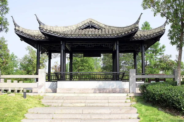 Chinese summer terrace on a hill. The architecture is oriental beautiful style with black round columns. Eastern construction culture, Chinese house.