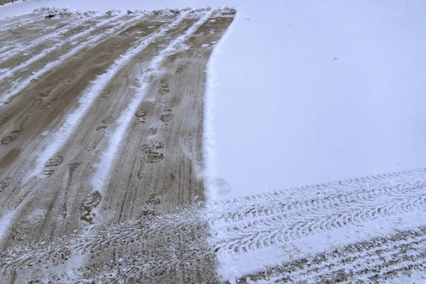 La neve cadde sulla strada, pulendo la neve. Tracce di auto sulla neve bianca. I sentieri spianati da una pala di neve. Il lavoratore pulisce la strada dalla neve . — Foto Stock