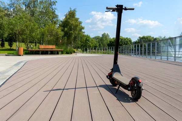 Een Elektrische Zwarte Scooter Staat Bandwagon Straat Stadspark Met Houten — Stockfoto