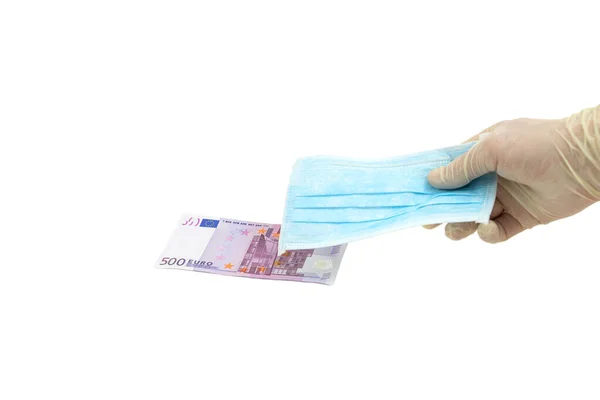 Koruyucu eldivenli bir el 500 avro karşılığında mavi bir tıbbi maske tutuyor. Avrupa 'dan maske alma fikri, virüse karşı koruma. İzole edilmiş beyaz arkaplan.