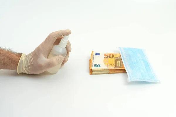 Ręka Białej Rękawiczce Obsługuje Antyseptyczny Banknot Euro Obok Niebieskiej Maski — Zdjęcie stockowe