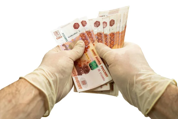 Beyaz koruyucu eldivenli iki el 5.000 ruble değerinde bir deste banknot sayıyor. İzole edilmiş beyaz arka plan. Virüs koruma kavramı.