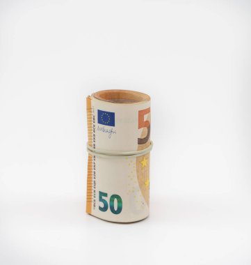 Banknotlar, elastik bantla bir rulo halinde elli elli avro. Tasarruf edilecek Avrupa para birimi. Yakın plan, beyaz arka plan. Mevduat ve paranın güvenliği kavramı.