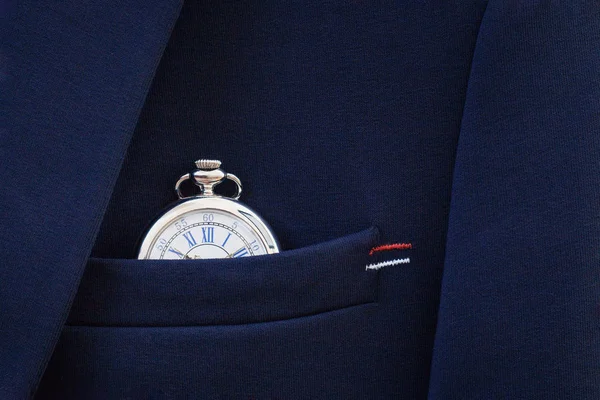 Pocket watch in the pocket of a blue blazer