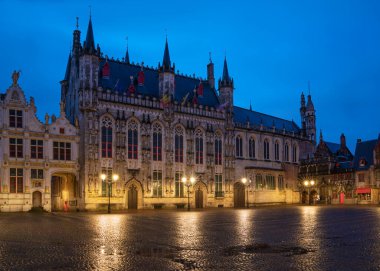 BRUGES, BELGIUM - NOVEMBER 2, 2019: Panoramic image of the historic townhall at daybreak, historic buildings of Bruges on November 2, 2019 in Belgium