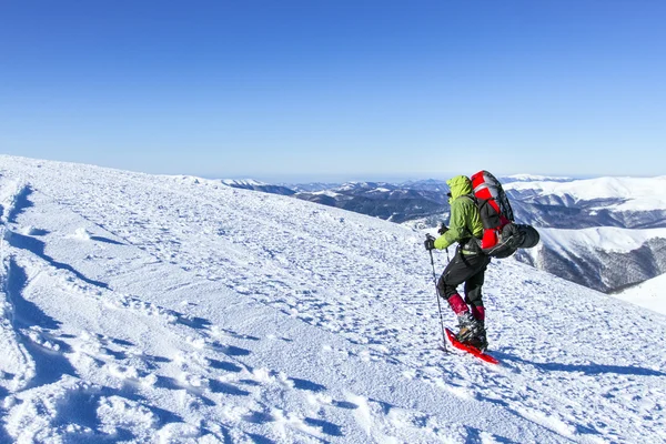 Χειμερινή πεζοπορία. Χειμερινές πεζοπορίες στα βουνά με χιονοπέδιλα με σακίδιο και τέντα. — Φωτογραφία Αρχείου