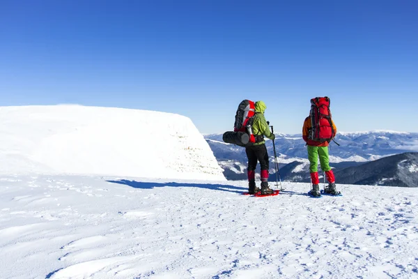 Vinter vandring. Vintern vandra i bergen på snöskor med en ryggsäck och tält. — Stockfoto