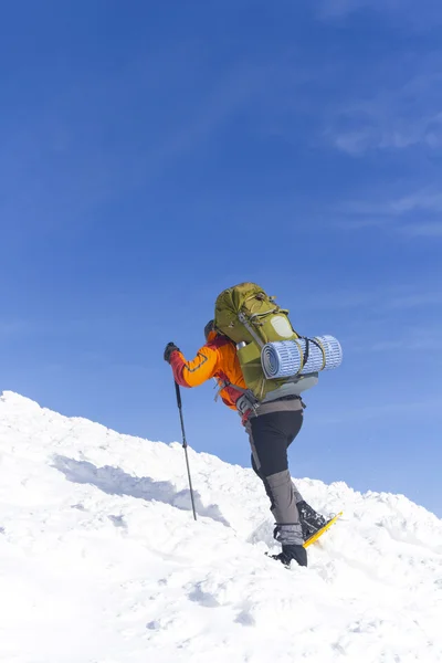 Hiking kış. Dağlarda kar ayakkabıları bir sırt çantası ve çadır hiking kış. — Stok fotoğraf