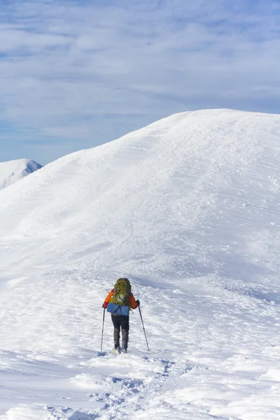 冬季徒步旅行。在山里徒步旅行带着背包和帐篷雪的冬天. — 图库照片