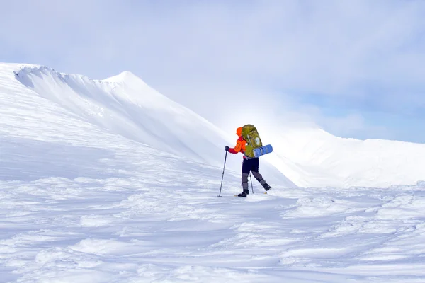 冬季徒步旅行。在山里徒步旅行带着背包和帐篷雪的冬天. — 图库照片