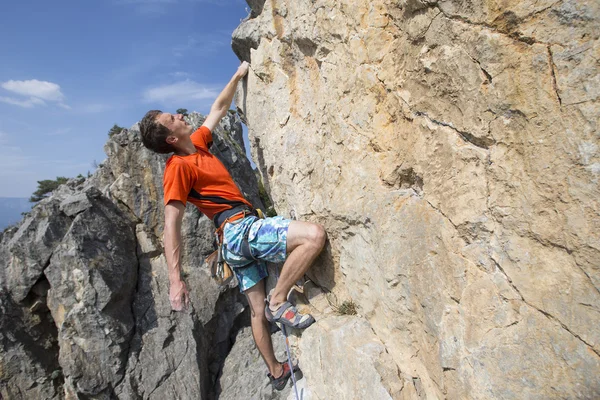 Cliffhanger.Rock klättrare klättra väggen. — Stockfoto