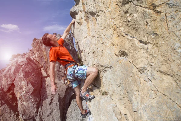 Cliffhanger.Rock klättrare klättra väggen. — Stockfoto