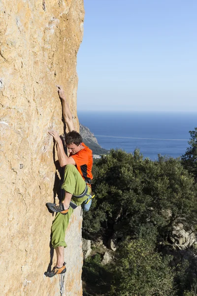 Cliffhanger.Rock klättrare klättra väggen. — Stockfoto