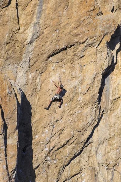 Cliffhanger.Rock klimmer te beklimmen van de muur. — Stockfoto
