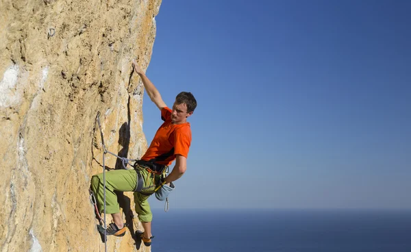 Cliffhanger.Rock klimmer te beklimmen van de muur. — Stockfoto