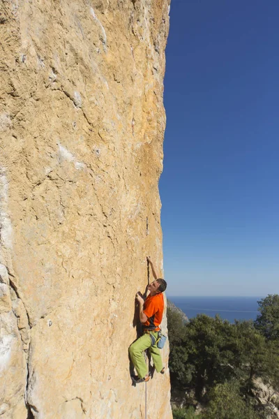 Cliffhanger.Rock klimmer te beklimmen van de muur. — Stockfoto