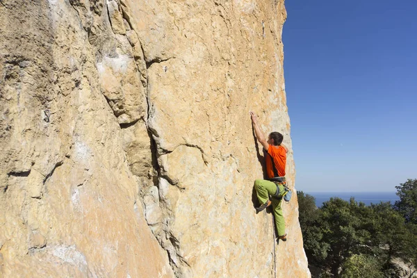 Cliffhanger.Rock klättrare klättra väggen. — Stockfoto