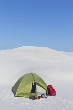Hiking kış. Güneşli kış dağlarda yeşil çadır.
