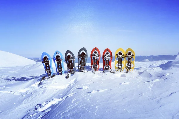 Senderismo de invierno en las montañas.Senderismo de invierno en las montañas en raquetas de nieve con una mochila y tienda de campaña . — Foto de Stock