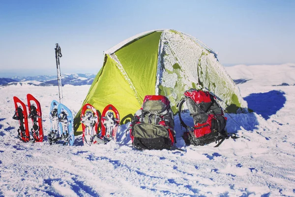 Caminhadas de inverno nas montanhas.Caminhadas de inverno nas montanhas em sapatos de neve com mochila e tenda . — Fotografia de Stock