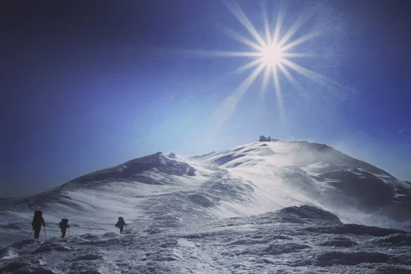 Vintern vandra i bergen. Vintern vandra i bergen på snöskor med en ryggsäck och tält. — Stockfoto