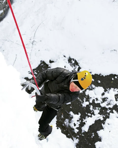 Lezení po ledu. Muž horolezecké zmrazené vodopád. — Stock fotografie