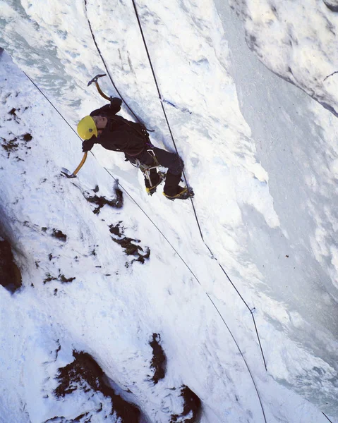 アイス クライミングします。男登山凍った滝. — ストック写真