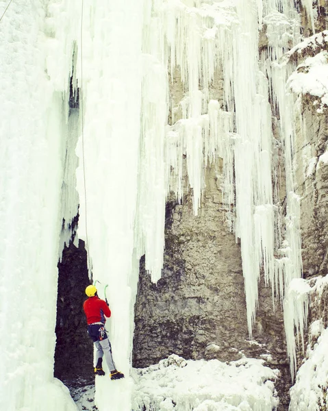 Arrampicata su ghiaccio.Uomo arrampicata cascata congelata . — Foto Stock